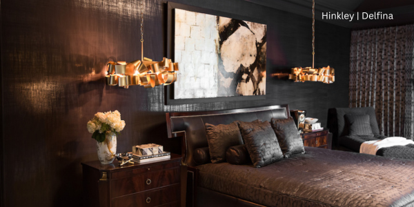 Bedroom in dark tones of brown with two pendant lights on either side of the bed. The lights are mix between bronze and gold in finish color.