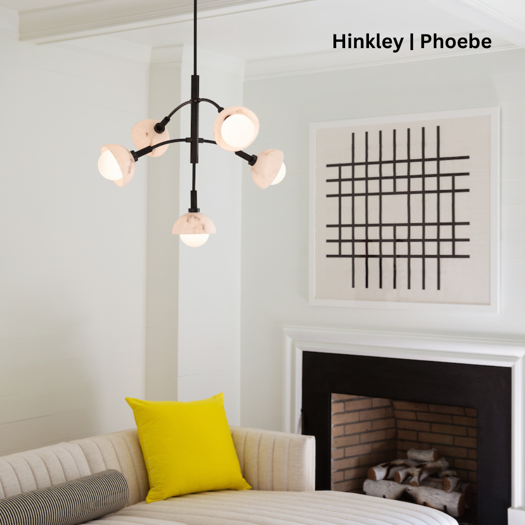 Black multi-tiered chandelier with ribbed stem detail hanging in front of a fireplace.