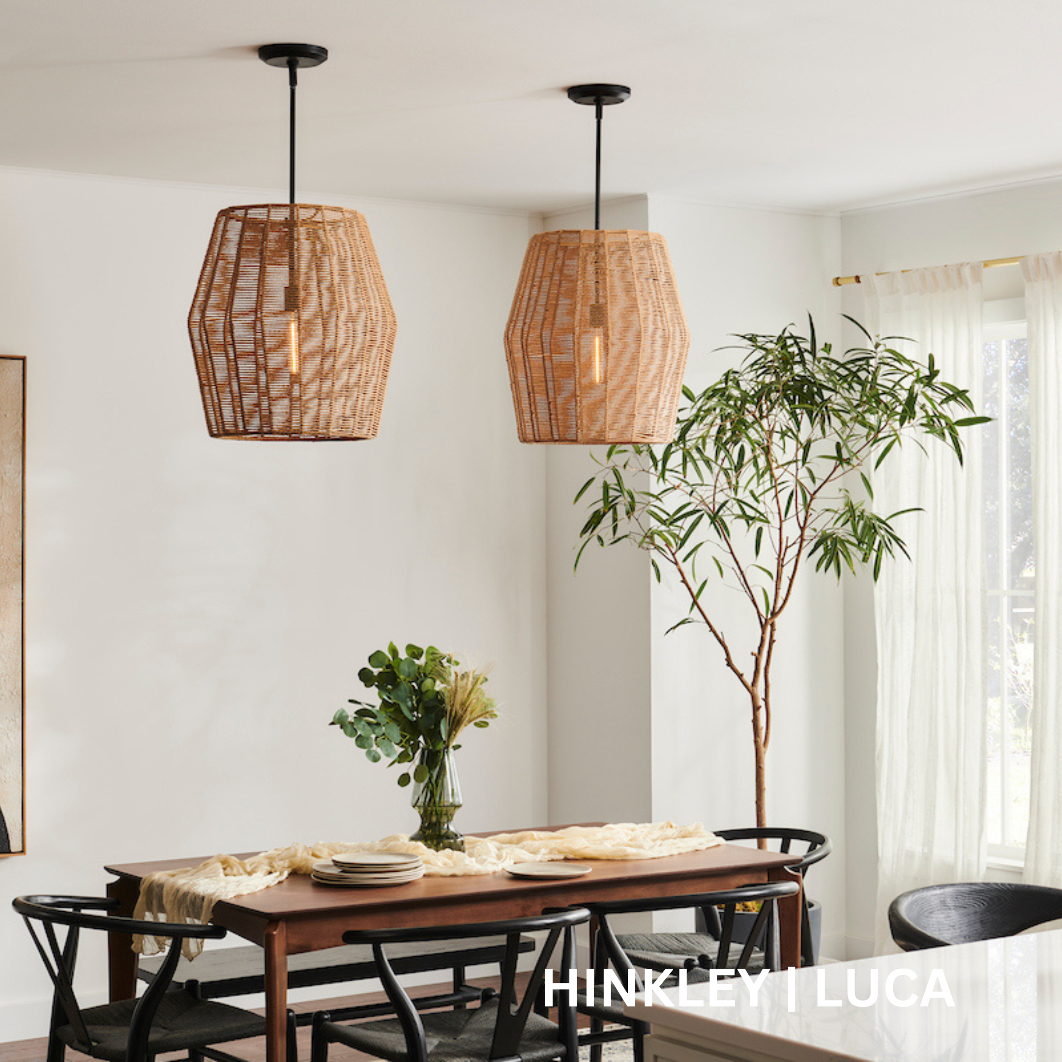 2 Tan, woven drum shade pendant lights hanging over a kitchen table.