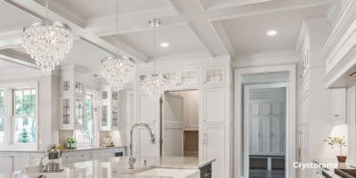 Crystal chandleries hanging in a white kitchen.