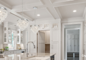Crystal chandleries hanging in a white kitchen.